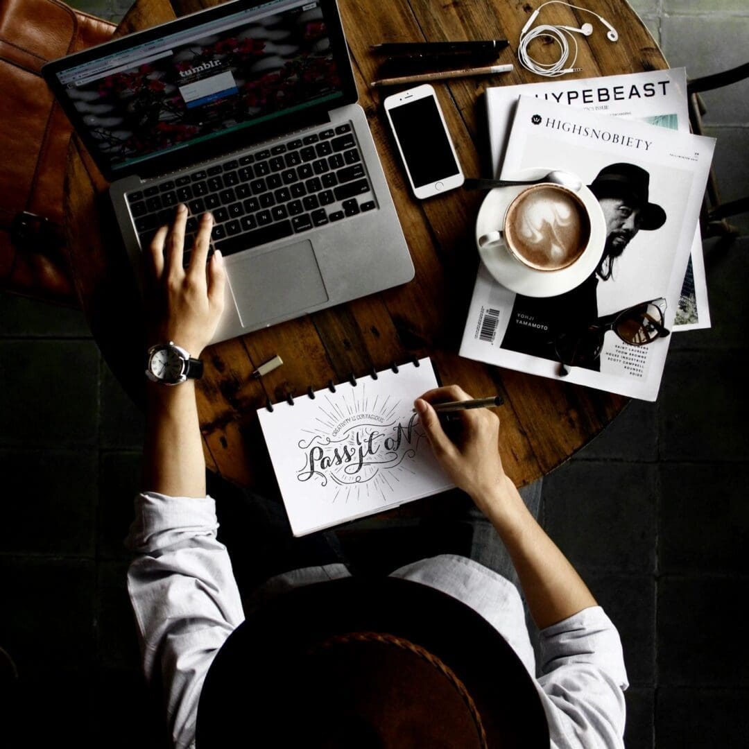A person working at a desk with a laptop and a cup of coffee, ready to start your journey.