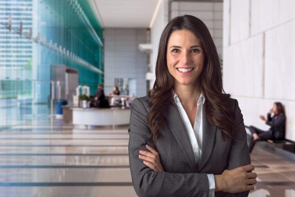 A smiling business woman in an office, ready to start your journey to transform your business.