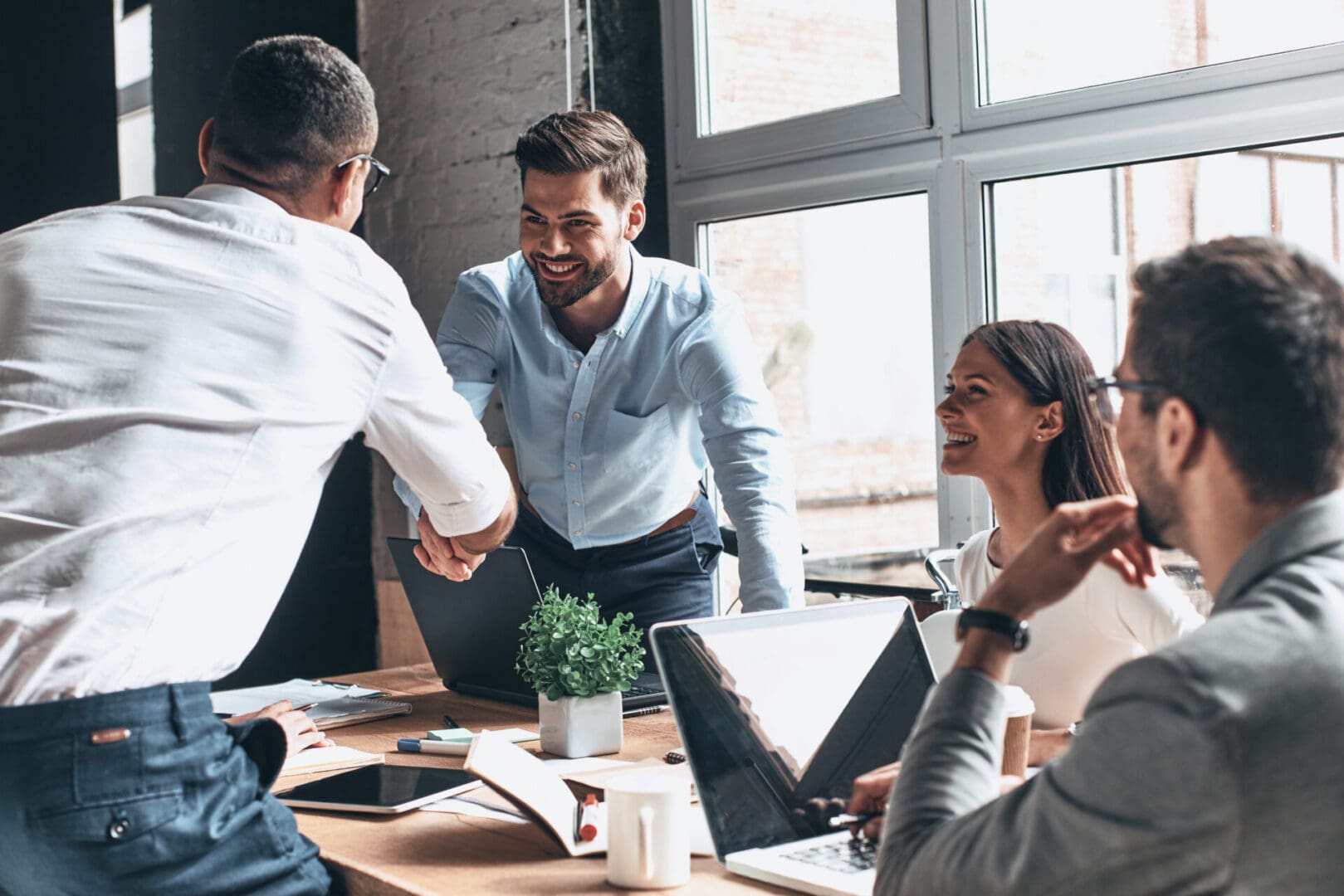 Colleagues shaking hands during collaborative meeting