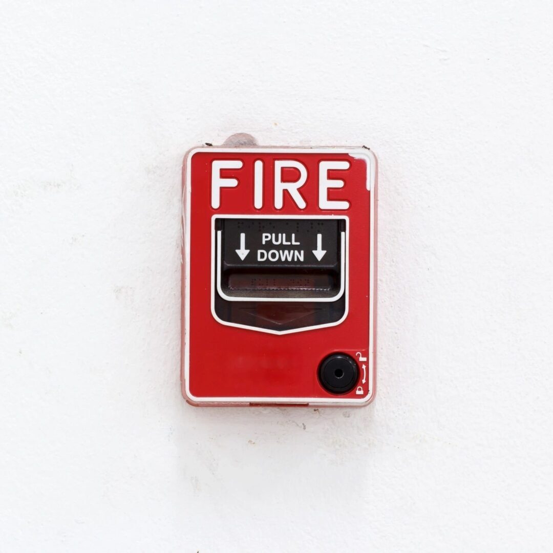 A fire extinguisher on a white wall.
