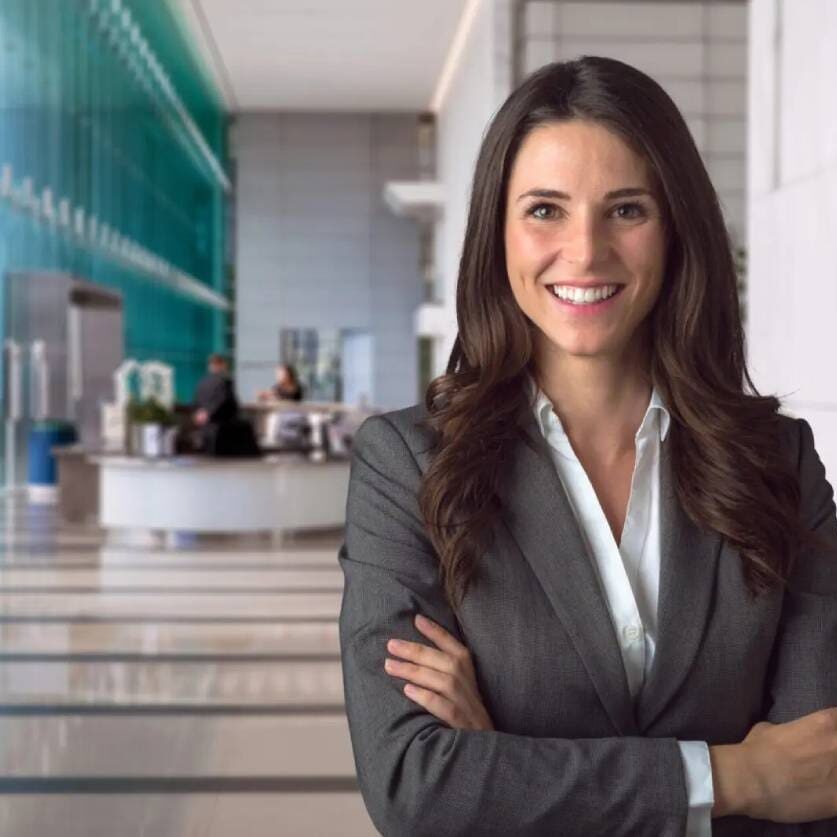 A smiling business woman enjoying her work in a stylish office setting.