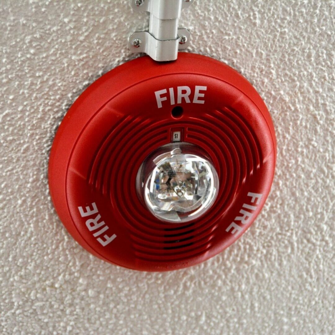 A red fire alarm hanging on a wall.